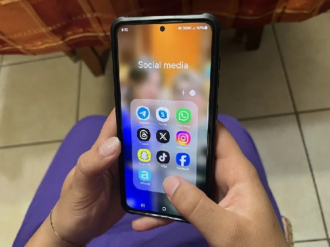 Un adolescente consulta su teléfono móvil.